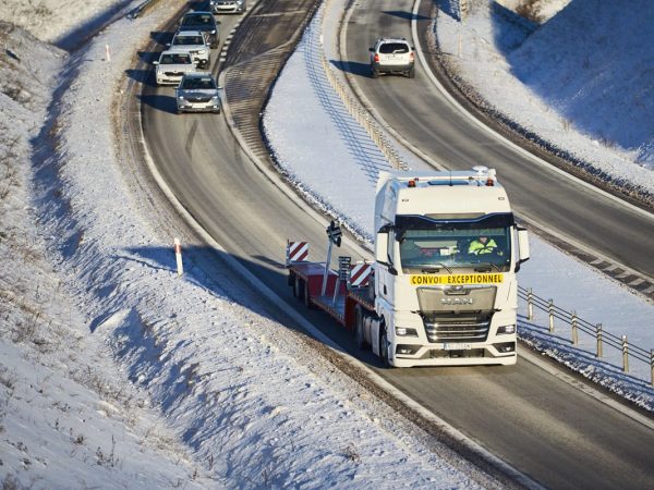 Ciągnik siodłowy New MBK na zaśnieżonej trasie – transport jachtu