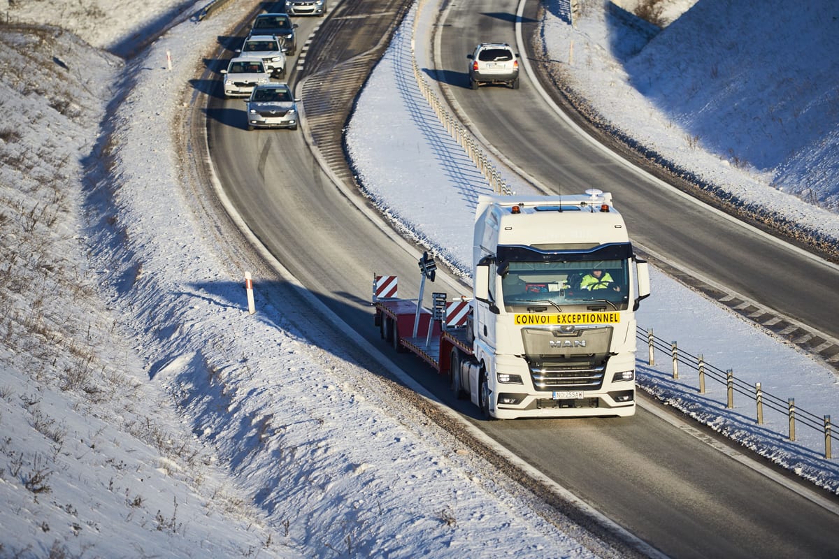 Ciągnik siodłowy New MBK na zaśnieżonej trasie – transport jachtu